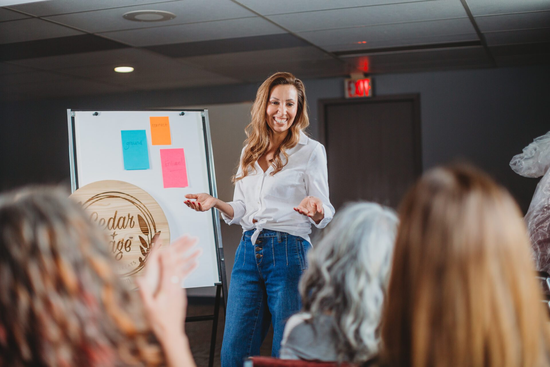 Darla stands in front of a small group, facilitating a workshop with a smile on her face.