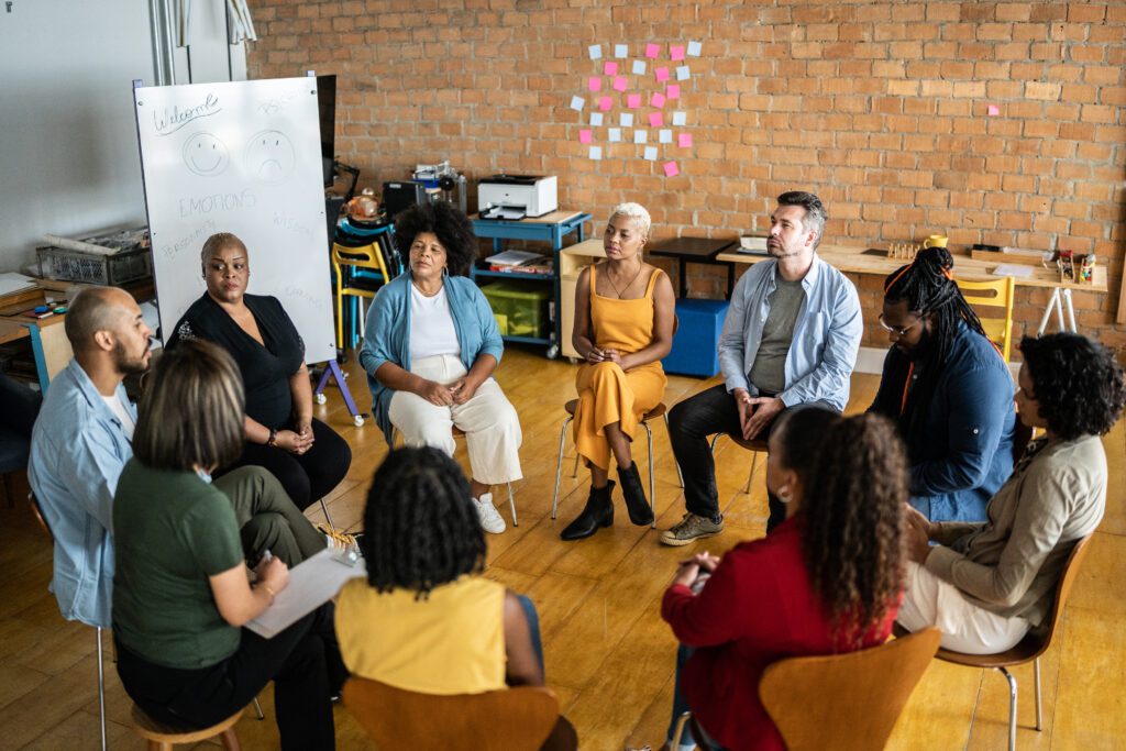 A group of women sit outside, meditating.